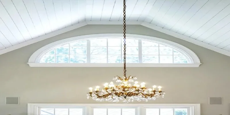 White vaulted ceiling above an arched window and chandelier